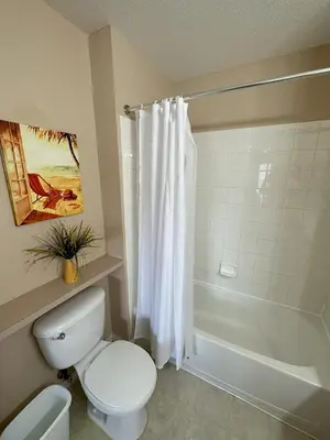 a bathroom with a white toilet and a shower at Casa 4 Quartos - 20min Disney - Seven Dwarfs in Kissimmee