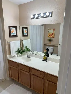 a bathroom with a sink and a large mirror at Casa 4 Quartos - 20min Disney - Seven Dwarfs in Kissimmee