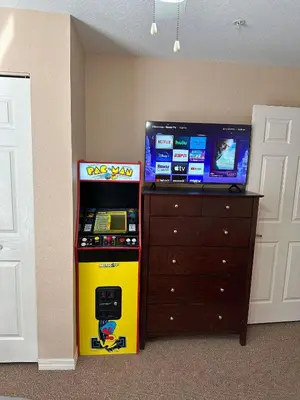 a video game machine sitting next to a dresser at Casa 4 Quartos - 20min Disney - Seven Dwarfs in Kissimmee