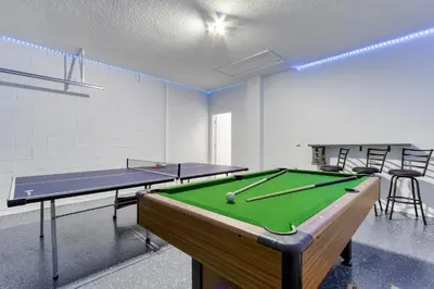 a room with a pool table and ping pong balls at Stunning 5 bedroom pool home in gated community minutes from Disney in Kissimmee