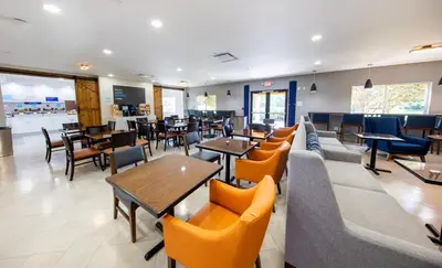 a restaurant with couches and tables and chairs at Holiday Inn Express & Suites Clermont SE - West Orlando by IHG in Orlando