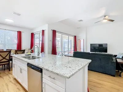 a kitchen with a counter top and a living room at Single Level 2 KING BEDS - 4BedrmPOOL-SPA-Disney in Orlando