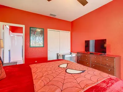 a red bedroom with a large bed and a flat screen tv at Single Level 2 KING BEDS - 4BedrmPOOL-SPA-Disney in Orlando
