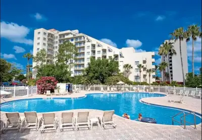 a pool with chairs and a building in the background at 6165 Carrier Drive Unit 1802 Building 1 in Orlando