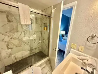 a bathroom with a shower and a sink and a tub at 6165 Carrier Drive Unit 1802 Building 1 in Orlando