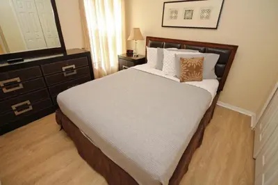a bedroom with a bed and a dresser and a mirror at Gorgeous 4 Bed Home In Gated Community in Kissimmee