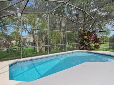 an empty swimming pool in a glass house at Gorgeous 4 Bed Home In Gated Community in Kissimmee