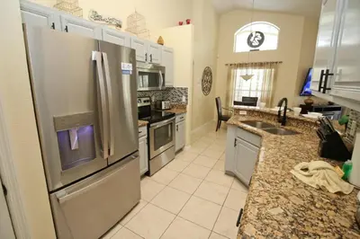 a kitchen with a stainless steel refrigerator and appliances at Gorgeous 4 Bed Home In Gated Community in Kissimmee
