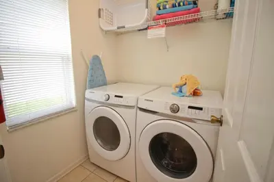 a washer and dryer in a small laundry room at Luxury Villa Private Pool And Great Game Room in Kissimmee