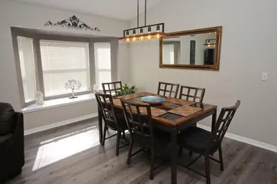 a dining room with a table and chairs and a mirror at Newly Renovated Home With Calming Atmosphere in Kissimmee