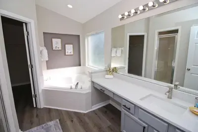 a white bathroom with a tub and a sink at Newly Renovated Home With Calming Atmosphere in Kissimmee