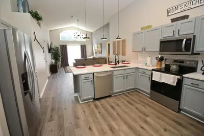 a kitchen with white cabinets and a wooden floor at Newly Renovated Home With Calming Atmosphere in Kissimmee