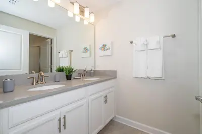 a bathroom with two sinks and a large mirror at 5011CL TOWNHOME 4 BEDS 3 BATHS FREE WATERPARK in Kissimmee