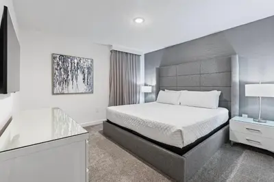 a white bedroom with a bed and a desk at New Home 9 Bedrooms and 5 Bathrooms At Storey Lake in Kissimmee