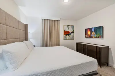 a bedroom with a large bed with white sheets at New Home 9 Bedrooms and 5 Bathrooms At Storey Lake in Kissimmee