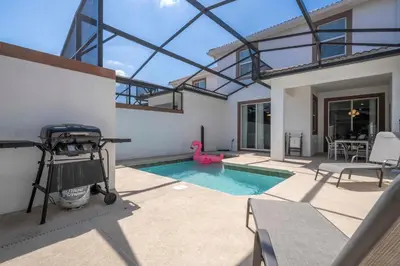 a backyard with a swimming pool and a house at Gorgeous 4Bd with Pool and Waterpark at Storey Lake 4836M in Kissimmee