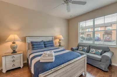 a bedroom with a bed and a couch and a window at 2711 - Jungle Book Bungalow - DO NOT DO in Orlando