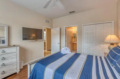 a bedroom with a bed and a dresser and a tv at 2711 - Jungle Book Bungalow - DO NOT DO in Orlando