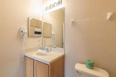 a bathroom with a sink and a mirror and a toilet at 2711 - Jungle Book Bungalow - DO NOT DO in Orlando