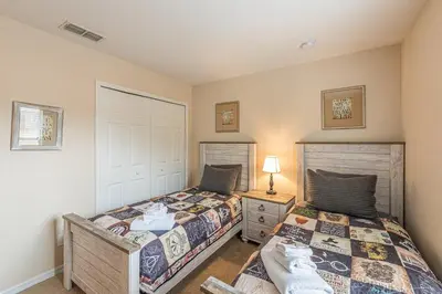 a bedroom with two beds and a lamp on a night stand at 2711 - Jungle Book Bungalow - DO NOT DO in Orlando