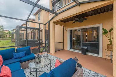 a patio with a blue couch and a glass table at 2711 - Jungle Book Bungalow - DO NOT DO in Orlando