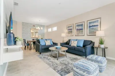 a living room with two blue couches and a table at 3120 Paradox Circle 301 in Kissimmee