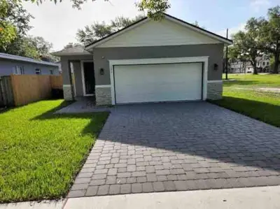 a house with a garage with a brick driveway at The Arcade close to downtown with fenced yard in Sanford