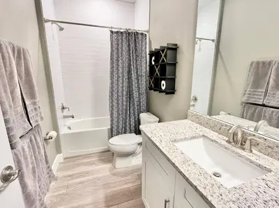 a white bathroom with a sink and a toilet at The Arcade close to downtown with fenced yard in Sanford