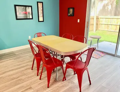 a wooden table and red chairs in a room at The Arcade close to downtown with fenced yard in Sanford
