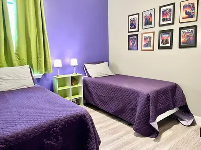 two beds in a room with purple and green at The Billiard close to downtown with fenced yard in Sanford