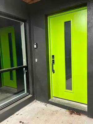 a green door on a building with a window at The Butterfly House - with sauna in Sanford