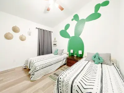 a bedroom with two beds and a mural of a rabbit at The Sanford Ave House with fully fenced yard in Sanford