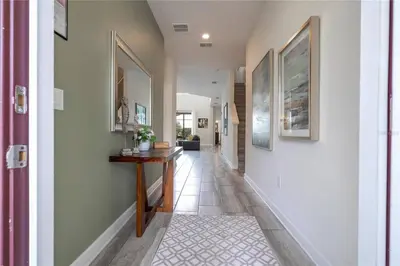 a hallway of a home with a table and paintings on the walls at Amazing home at Storey lake 2 minutes to clubhouse in Kissimmee