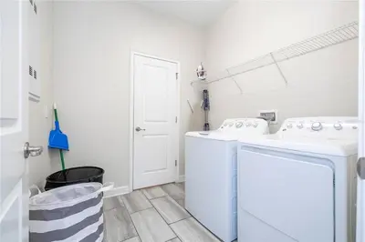a white laundry room with two sinks and a washing machine at Amazing home at Storey lake 2 minutes to clubhouse in Kissimmee