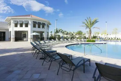 a group of chairs sitting next to a swimming pool at Amazing home at Storey lake 2 minutes to clubhouse in Kissimmee