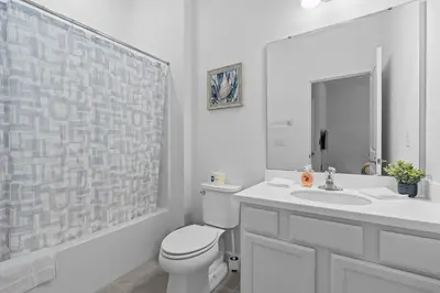a white bathroom with a toilet and a sink at Cozy Master Room with Private Bath in Kissimmee