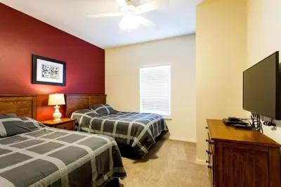a bedroom with two beds and a flat screen tv at Your VIP Home in Orlando Disney 25106 in Kissimmee