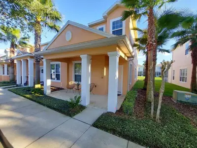 a house with palm trees in front of it at Serenity Close to Disney Orlando in Orlando