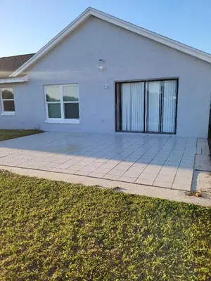 a white house with a large driveway at Nard Jolie Kay in Kissimmee