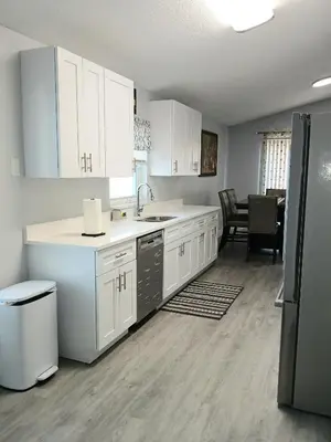 a kitchen with white cabinets and a stainless steel refrigerator at Nard Jolie Kay in Kissimmee