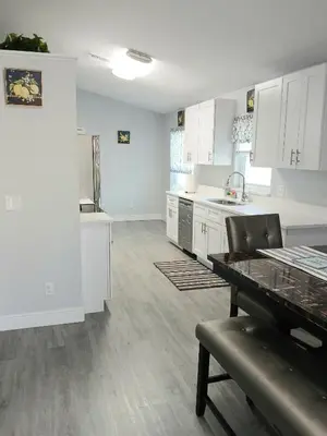 a large kitchen with white cabinets and a table at Nard Jolie Kay in Kissimmee