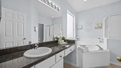 a white bathroom with a sink and a mirror at Ever After Adventure Villa - Themed Rooms, Game Room, Private Pool Near Disney in Kissimmee