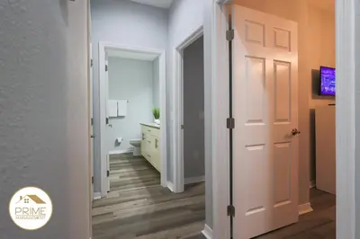 a hallway with a white door and a bedroom at NEW Renewed 3BD Modern 10 Min to Disney in Kissimmee