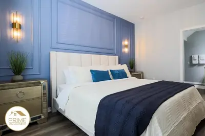 a bedroom with a large bed with blue walls at NEW Renewed 3BD Modern 10 Min to Disney in Kissimmee