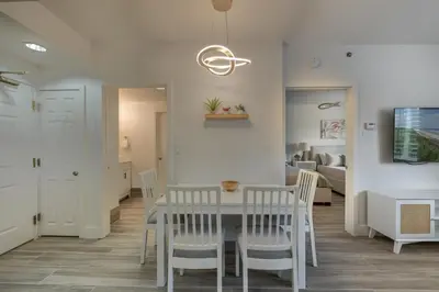 a dining room and living room with a table and chairs at Pool view apartment near Epic Universe and Universal Studios in Orlando