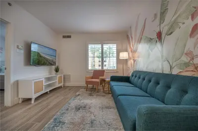 a living room with a blue couch and a tv at Pool view apartment near Epic Universe and Universal Studios in Orlando