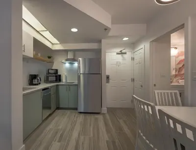 a kitchen with a refrigerator and a table with chairs at Pool view apartment near Epic Universe and Universal Studios in Orlando