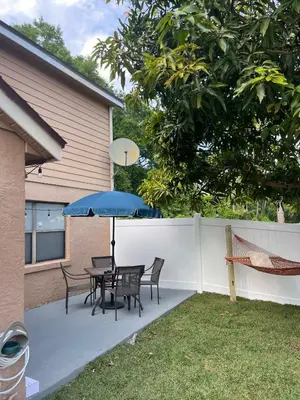 a patio with a table and chairs and an umbrella at NEW Designed Apt 2023 NrUCF PETSOk PrivateEntry in Orlando