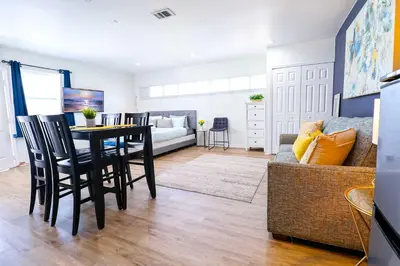 a living room with a table and chairs and a couch at NEW5 LUXURYSTUDIO Nr DISNEY PETSOKprivENTRY in Kissimmee