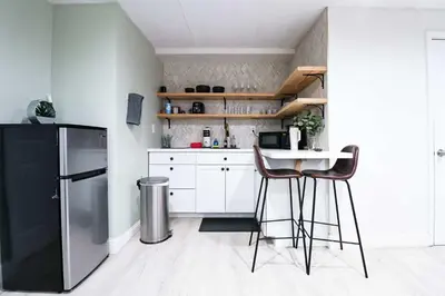 a kitchen with white cabinets and a black refrigerator at BRANDNEW 2023 LAKEFRONT APT in Kissimmee